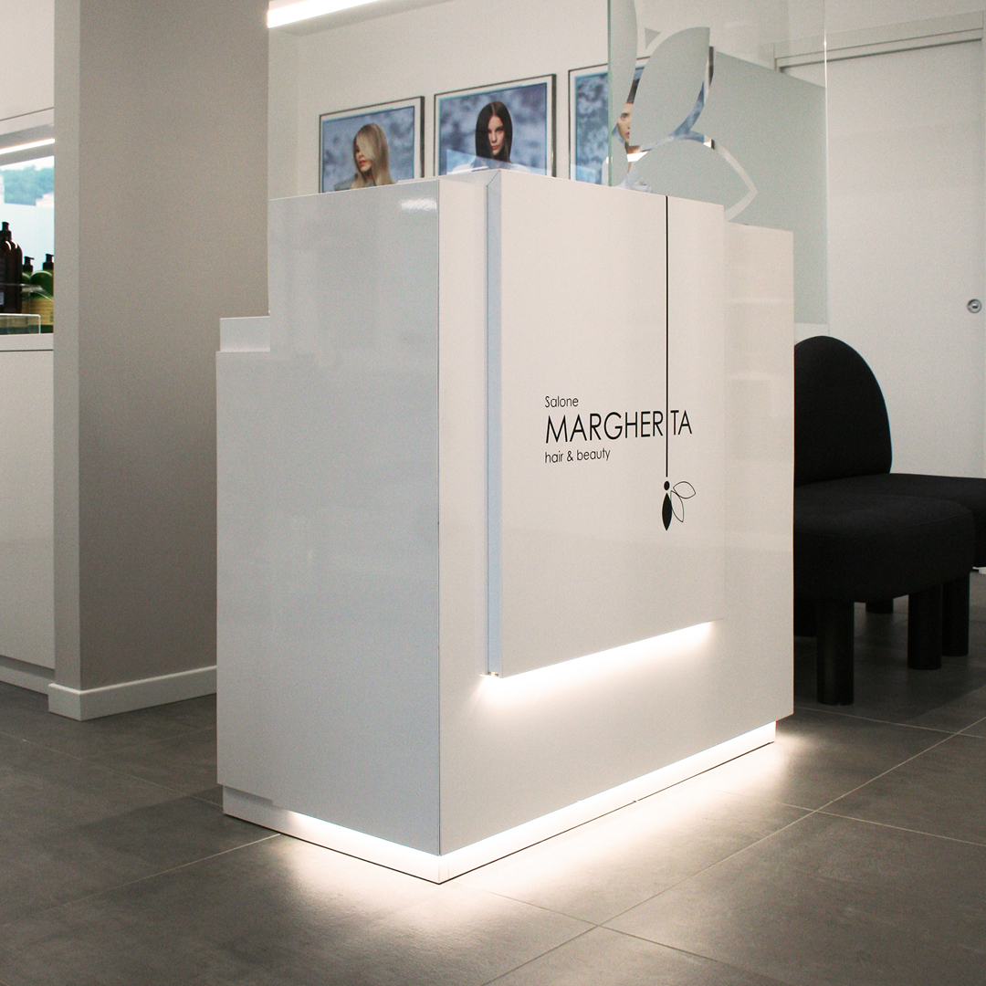 Immagine del bancone del salone, tutto bianco, illuminato sotto